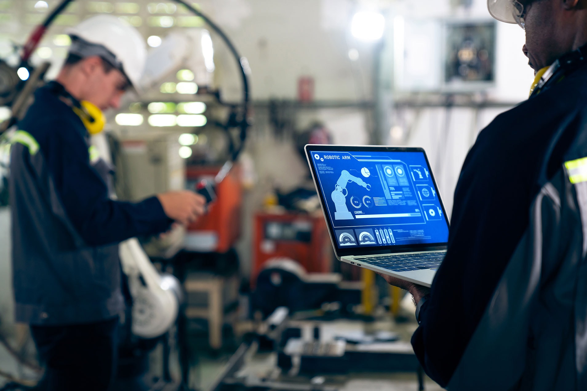 Industrial team reviewing operational software and production information in a factory.